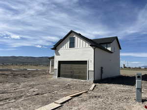 View of home's exterior with an attached garage, driveway, board and batten siding, and a mountain view