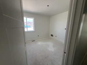 Empty room featuring baseboards and visible vents