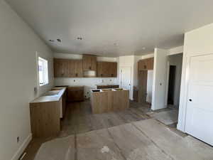 Kitchen featuring brown cabinetry, baseboards, and a kitchen island