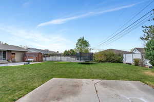 View of yard with an outdoor structure, a patio area, a shed, and a trampoline