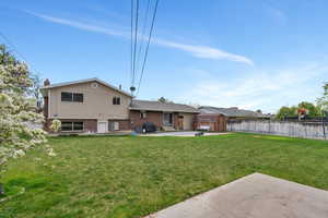 Back of house with fence, an outdoor structure, a patio, a storage unit, and brick siding