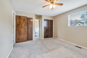 Bedroom featuring baseboards, visible vents, a textured ceiling, and carpet flooring