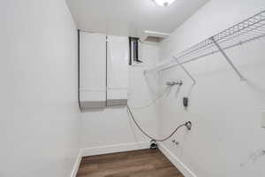 Laundry room with hookup for a washing machine, wood finished floors, baseboards, gas dryer hookup, and laundry area