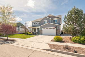 Craftsman house with fence, board and batten siding, driveway, stone siding, and a front yard