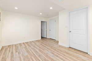 Spare room featuring light wood-type flooring, baseboards, and recessed lighting