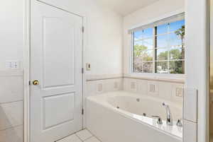 Bathroom featuring tile patterned flooring and a jetted tub