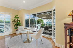 Seating Area  featuring wood finished floors, crown molding, and baseboards