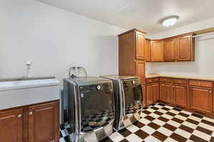 Washroom with light floors, cabinet space, visible vents, and independent washer and dryer