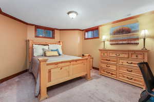 Bedroom featuring baseboards, visible vents, light colored carpet, and crown molding