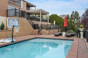 View of pool featuring a fenced in pool, stairs, fence, a patio, and a mountain view