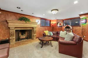 Carpeted living room featuring a fireplace, recessed lighting, and ornamental molding