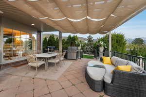 Entertaining patio featuring grilling area, a mountain view, outdoor dining space, and seating area.