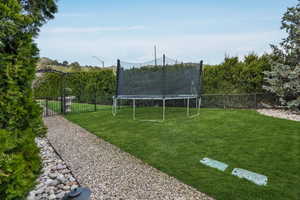 View of yard with a trampoline and a fenced backyard