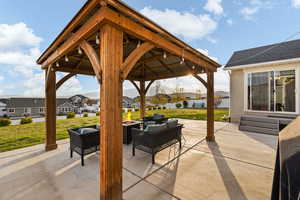 View of patio with a gazebo, an outdoor living space with a fire pit, a residential view, and a mountain view