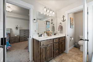 Bathroom featuring double vanity, toilet, and a sink