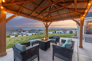 View of patio with a mountain view, a gazebo, an outdoor living space with a fire pit, and a residential view