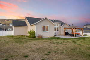 Rear view of property with fence, a lawn, a gazebo, and a patio