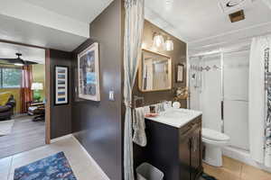 Bathroom featuring a shower stall, tile patterned flooring, and toilet