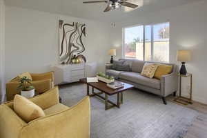 Living area with ceiling fan, baseboards, visible vents, and light wood-style flooring