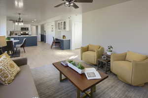 Living room featuring ceiling fan with notable chandelier and light wood-style flooring