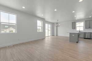 Unfurnished living room with a chandelier, recessed lighting, and light wood-style flooring