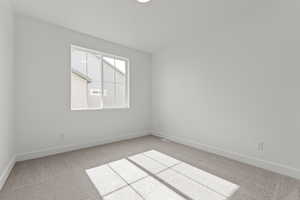 Carpeted empty room featuring baseboards