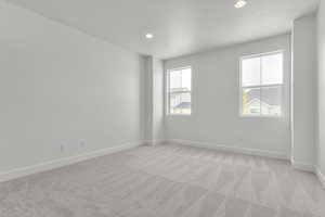 Empty room featuring plenty of natural light, light carpet, and recessed lighting