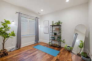 Workout area featuring baseboards, wood finished floors, recessed lighting, and plenty of natural light