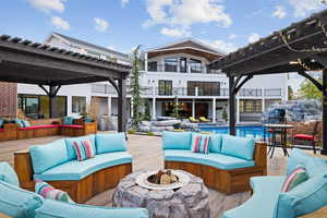 View of patio with an outdoor living space with a fire pit, a pergola, an outdoor pool, and a balcony