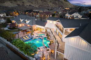 View of swimming pool featuring a pool with connected hot tub, a residential view, a fenced backyard, a patio area, and a mountain view