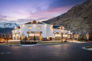 View of front of property with a mountain view, a balcony, board and batten siding, driveway, and an attached garage