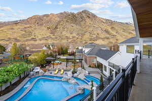 View of swimming pool featuring a mountain view, a fenced backyard, a patio area, and a pool with connected hot tub