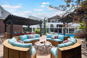 View of patio featuring an outdoor living space with a fire pit, a pergola, and an outdoor pool