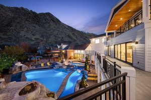 View of swimming pool featuring a mountain view, a pool with connected hot tub, and a patio
