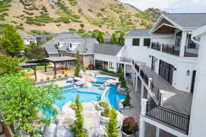 View of swimming pool with a pool with connected hot tub, a pergola, a mountain view, and a patio