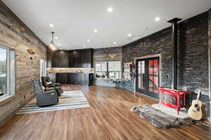 Living area with a wood stove, wood finished floors, wood walls, and recessed lighting