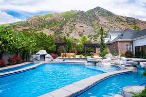 Outdoor pool with a pergola, a mountain view, and a patio
