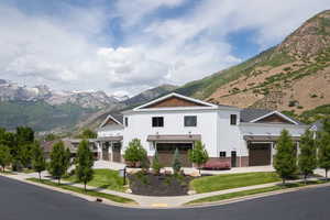 Modern farmhouse featuring a mountain view, a standing seam roof, board and batten siding, an attached garage, and metal roof