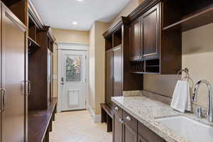 Mudroom with a sink, light tile patterned floors, baseboards, and recessed lighting