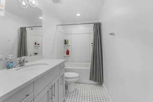 Full bathroom with recessed lighting, shower / bathtub combination with curtain, visible vents, toilet, and vanity