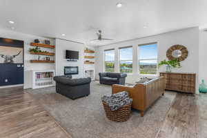 Living area featuring recessed lighting, wood finished floors, a large fireplace, and ceiling fan