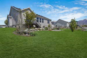 ***grass is enhanced to show what it could look like, current yard is more dirt***Rear view of property featuring stairway, a lawn, and a residential view