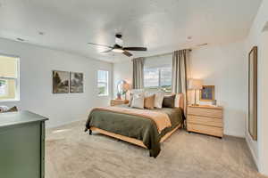 Bedroom featuring light colored carpet, ceiling fan, baseboards, and visible vents