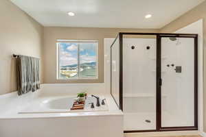 Full bath featuring recessed lighting, a bath, and a shower stall