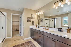 Full bath featuring wood finished floors, a sink, visible vents, and a stall shower