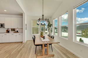 Dining space featuring a chandelier, light wood-style flooring, baseboards, and recessed lighting
