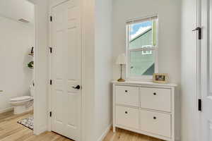 Hall featuring baseboards, light wood-style floors, and visible vents
