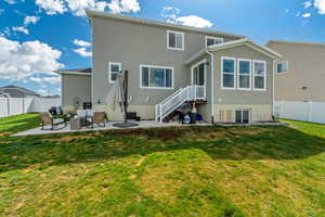 Back of house featuring a yard, a fenced backyard, a patio, and stucco siding