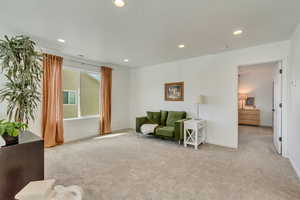 Sitting room featuring baseboards, light carpet, visible vents, and recessed lighting
