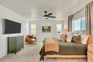 Bedroom with light carpet, baseboards, and ceiling fan